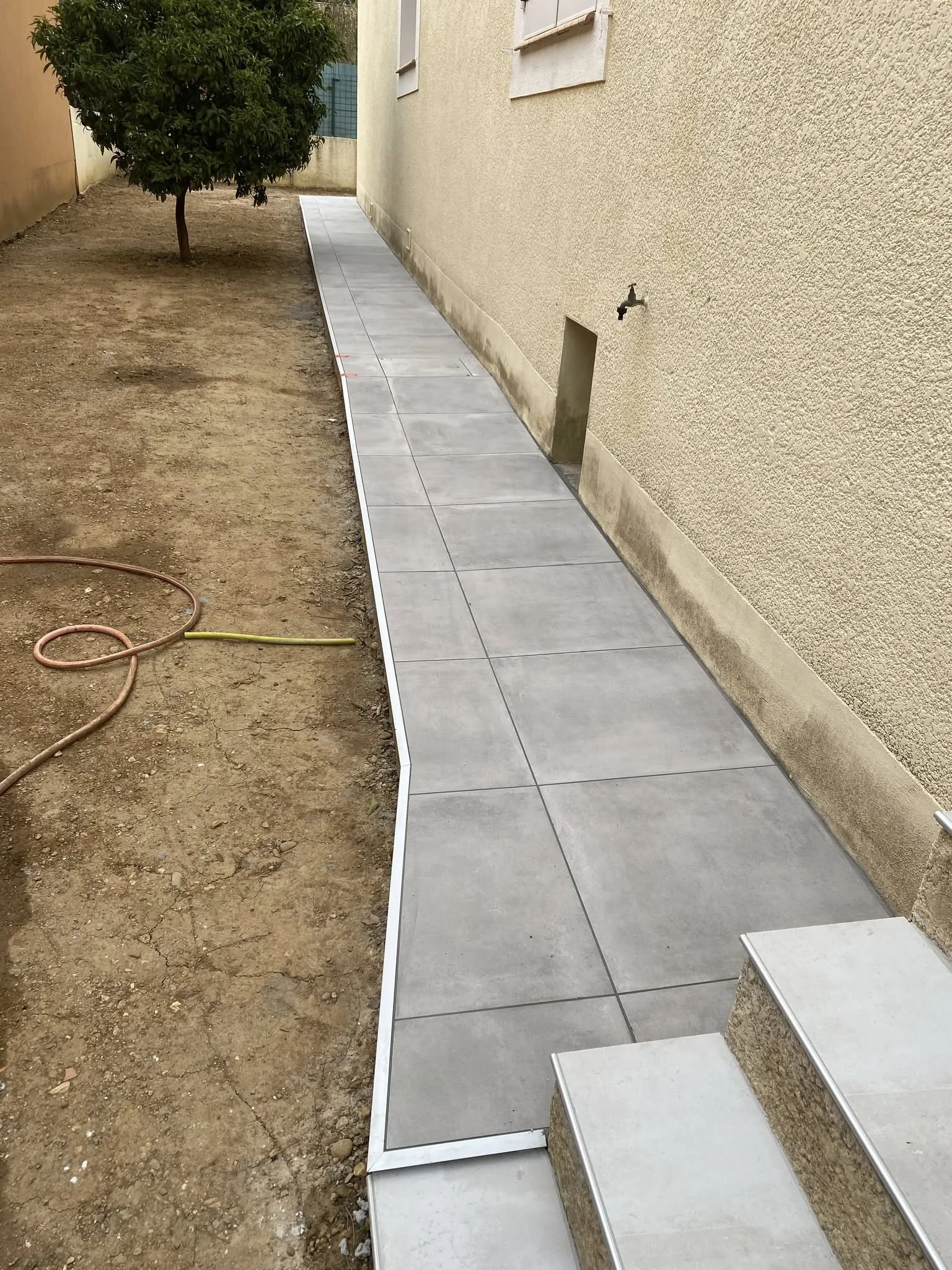 Allée extérieure carrelée le long d’une maison